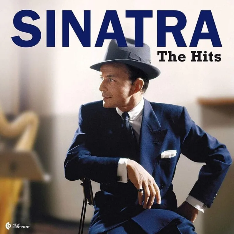 Portada de The Hits: Frank Sinatra con sombrero y traje azul, sentado en una silla